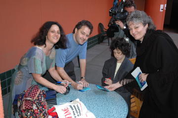 Coin designers Garrett, Michelle and Katie Burke sign autographs.